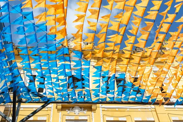 Haziran şenliklerini süsleyen renkli afişler. Plastik nesneler yukarıda asılı. Pelourinho, Brezilya.