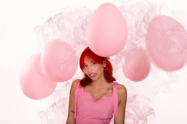 Fotoğraf stüdyosu için poz veren pembe hava balonları içindeki güzel kızıl saçlı doğum günü kızının portresi.