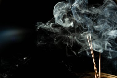 Tütsü çubuğunun ucundan çıkan mavi-beyaz duman. Stüdyo çekimi.