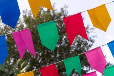 Mavi gökyüzüne karşı dekorasyon için renkli plastik flamalar. Dekoratif nesneler.