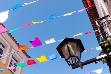 Mavi gökyüzüne karşı dekorasyon için renkli plastik flamalar. Dekoratif nesneler.