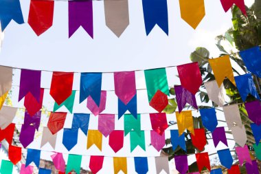 Mavi gökyüzüne karşı dekorasyon için renkli plastik flamalar. Dekoratif nesneler.