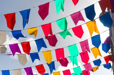 Mavi gökyüzüne karşı dekorasyon için renkli plastik flamalar. Dekoratif nesneler.