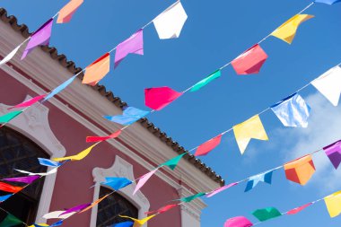 Mavi gökyüzüne karşı dekorasyon için renkli plastik flamalar. Dekoratif nesneler.
