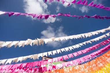 Plastik dekoratif nesneler. Sokaktaki evlerden sarkan renkli dekoratif bayraklar. Süsler.