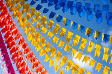 Plastik dekoratif nesneler. Sokaktaki evlerden sarkan renkli dekoratif bayraklar. Süsler.