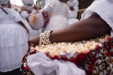 Salvador, Bahia, Brezilya - 16 Ağustos 2025: Saint Roque, Obaluae, Salvador, Brezilya 'da düzenlenen ziyafet gününde Candomble' ın takipçileri ellerinde patlamış mısır sepetleri taşırken görüldü.