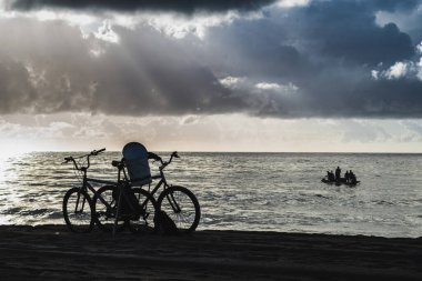 Tanımlanamayan balıkçılar gölgede kanoda balık ağı atıyorlar. Balıkçılık hobisi. Brezilya