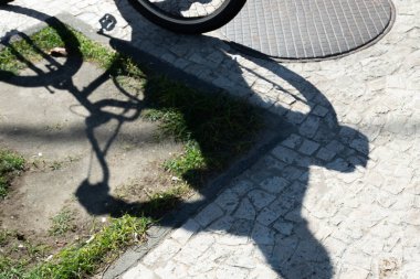 Bisikletin gölgesi bisiklet yoluna yansıtılıyor. Egzersiz yapan biri. Bisikletçi iş başında. Yaşam tarzı, spor pratiği..