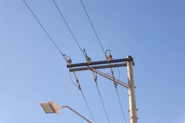 Mavi gökyüzüne karşı bir elektrik direği manzarası. Güç iletim ağı. Teknoloji.