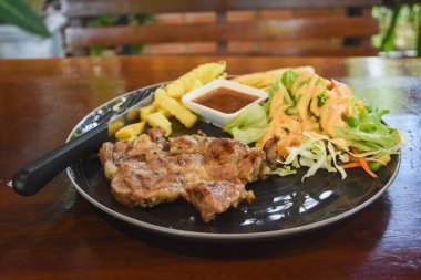 Yemek için hazır bir tabakta domuz boyunlu biftek.