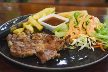 Yemek için hazır bir tabakta domuz boyunlu biftek.