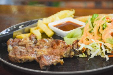 Yemek için hazır bir tabakta domuz boyunlu biftek.