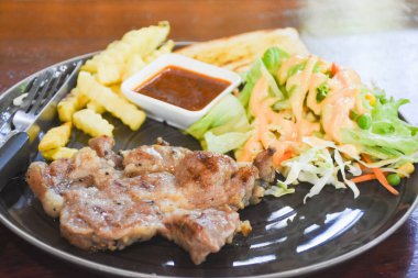 Yemek için hazır bir tabakta domuz boyunlu biftek.