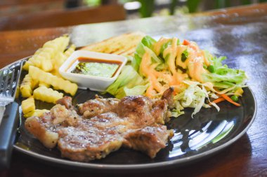 Yemek için hazır bir tabakta domuz boyunlu biftek.