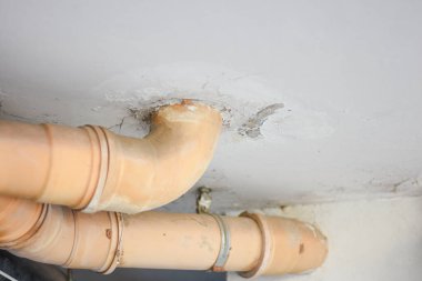 Binanın altındaki sarı kanalizasyon borusu.