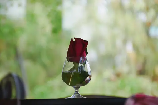Glass with roses on the table