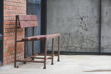 Tuğla duvar önünde ahşap sandalye