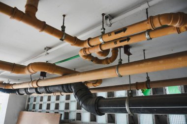 Binanın altındaki sarı kanalizasyon borusu.