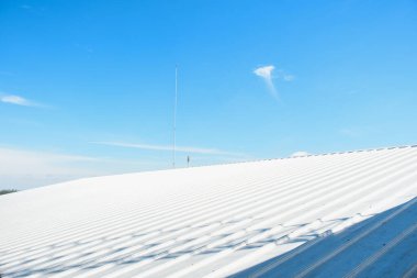 Mavi gökyüzü ile ticari yapım üzerine metal kaplama çatı.