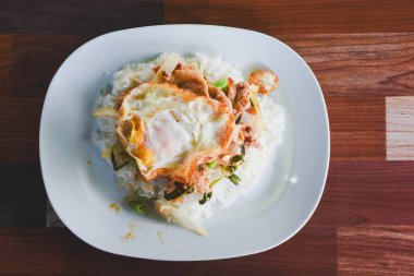 Fesleğenli domuz eti ve pirinçli kızarmış yumurta masada yemek için hazır..
