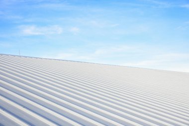 Mavi gökyüzü ile ticari yapım üzerine metal kaplama çatı.