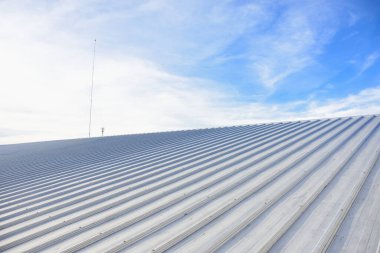 Mavi gökyüzü ile ticari yapım üzerine metal kaplama çatı.