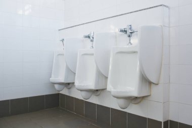 Zemin ayakta duran pisuvar, erkek umumi tuvalet, erkekler tuvaletinde kapalı beyaz pisuar, erkekler için beyaz seramik sidik tasarımı.