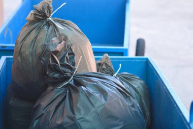 Mavi arabadaki siyah çöp torbası.