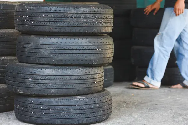 Servis garajının arka planında lastik tamiri. Güvenlik gezisi için kış ve yaz lastiklerini değiştiren teknisyen. Ulaşım ve otomotiv bakım kavramı