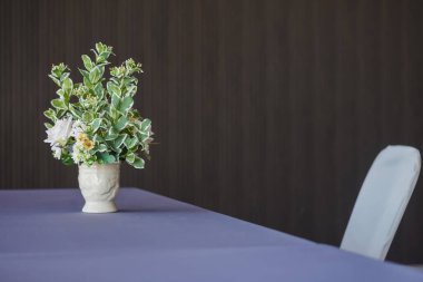 Konferans odasındaki bir masanın üstündeki vazoda çiçekler.