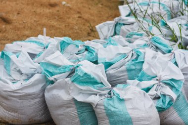 Sel koruması için beyaz ve mavi kum torbaları