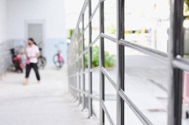 Bir patika ya da yürüyüş yolu boyunca metal korkulukların yakın çekim görüntüsü. Parmaklık parlak metal parmaklıklardan yapılmış ve görüntünün sağ tarafına yerleştirilmiş..