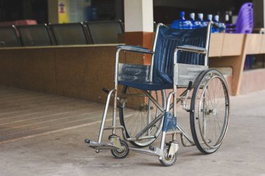 Tekerlekli sandalye, engelli kişinin bağımsızlık ve katılımına izin verme amacını vurgulamak için rampanın önüne ve bankın yanına yerleştirilir..