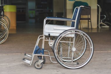Tekerlekli sandalye, engelli kişinin bağımsızlık ve katılımına izin verme amacını vurgulamak için rampanın önüne ve bankın yanına yerleştirilir..