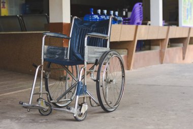Tekerlekli sandalye, engelli kişinin bağımsızlık ve katılımına izin verme amacını vurgulamak için rampanın önüne ve bankın yanına yerleştirilir..