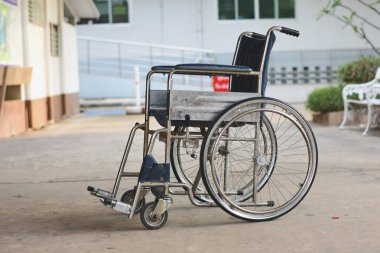 Tekerlekli sandalye, engelli kişinin bağımsızlık ve katılımına izin verme amacını vurgulamak için rampanın önüne ve bankın yanına yerleştirilir..