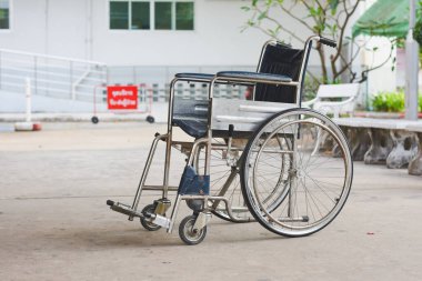 Tekerlekli sandalye, engelli kişinin bağımsızlık ve katılımına izin verme amacını vurgulamak için rampanın önüne ve bankın yanına yerleştirilir..