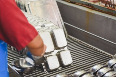 Çoklu paslanmaz çelik tepsiler dikey olarak istiflenmiş. Düzen düzgün ve verimli görünüyor..