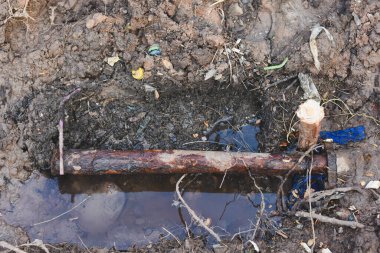 İnşaattaki hasarlı çelik su borularının yakın çekim görüntüsü.