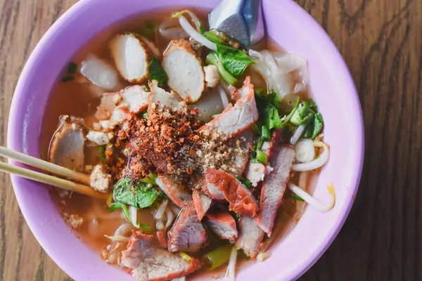 Clear soup noodles with pork and vegetables and fish balls and red pork