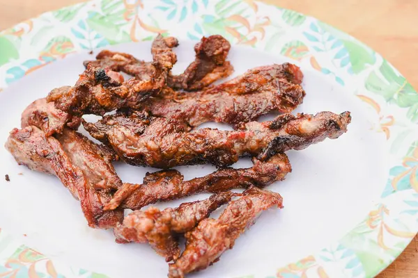 Tabakta servis edilen birkaç parça pişmiş, ızgara ya da kızarmış etin yakın çekim görüntüsü.