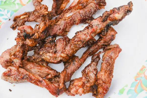 Tabakta servis edilen birkaç parça pişmiş, ızgara ya da kızarmış etin yakın çekim görüntüsü.