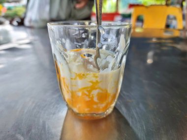 Temiz bardakta haşlanmış yumurta. Sabahleyin sıcak çayla ye. Tayland 'da bir dükkanda paslanmaz çelik bir masaya yerleştirilmiş.