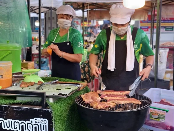 Songkhla, Tayland. 29 Ekim 2022 - İki kadın tüccar bit pazarında biftek yapmak için ızgara yapıyorlar..
