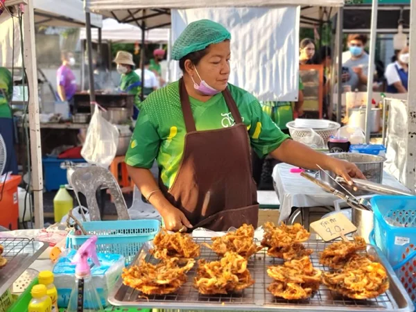 Songkhla-Tayland. 29 Ekim 2022 - Dişi bir tüccar bit pazarında haşlanmış karides kızartıyor.