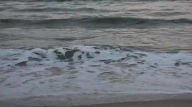 Dalgalar kumlu plaja çarptı. Akşamüstü