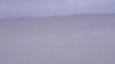 Dalgalar kumlu plaja çarptı. Akşamüstü