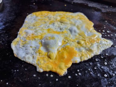 Sıcak, siyah bir panele yumurta kır. Pişirmeye hazır ol. Üst görünüm.