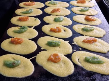 Tayland tatlıları (Tokyo tatlıları, Tokyo tatlıları, Khanom Tokyo) ve Tayland 'da sokak yemekleri için bir sobanın üzerindeki pankekler. Sarı krema dolguları ve yeşil pandan kreması dolguları var..